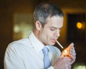 Homem adulto médio acendendo cigarro . — Fotografia de Stock