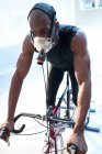 Athlete in oxygen mask riding exercise bike with measuring of oxygen consumption. — Stock Photo
