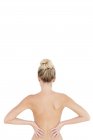 Rear view of blonde woman with hands on hips on white background — Stock Photo