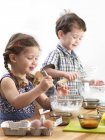Preschooler twins baking in domestic kitchen. — Stock Photo