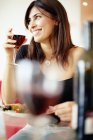 Femme adulte moyenne buvant du vin pendant le dîner au restaurant . — Photo de stock