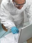 Cientista forense tira provas forenses do portátil . — Fotografia de Stock