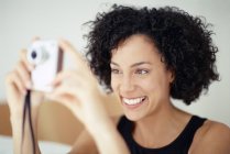 Femme mixte prenant des photos avec appareil photo et souriant
. — Photo de stock