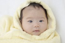Baby girl wrapped in towel, portrait. — Stock Photo