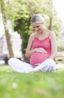 Donna incinta con mano sulla pancia — Foto stock