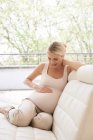 Pregnant woman with hand on tummy — Stock Photo