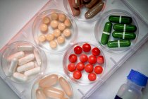 Variety of pills of different shapes in petri dishes, top view. — Stock Photo
