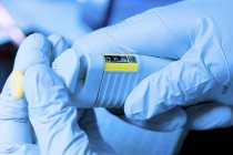 Close-up of electronic pipette in gloved hands. — Stock Photo