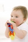 Portrait of baby boy chewing on teething ring. — Stock Photo