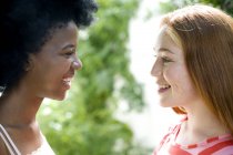 Dos chicas adolescentes hablando entre sí al aire libre . - foto de stock