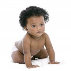 Baby girl on all fours on white background. — Stock Photo