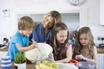 Mère avec fils et filles cuisinant dans la cuisine . — Photo de stock