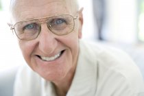 Портрет счастливого пожилого человека в классических очках, смотрящего в камеру — стоковое фото