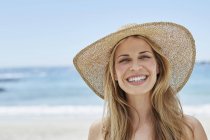 Ritratto di donna che indossa un cappello da sole sulla spiaggia . — Foto stock