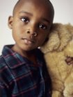 Niño preescolar en pijama sosteniendo un oso de peluche . - foto de stock