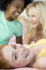 Three cheerful teenage girls laughing while hanging out indoors. — Stock Photo