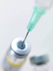 Needle inserted into vaccine vial. — Stock Photo