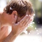 Hombre lavando la cara con agua fría . - foto de stock