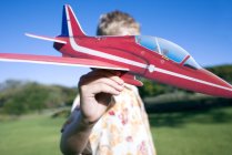 Хлопчик грає з моделлю літака в парку . — стокове фото