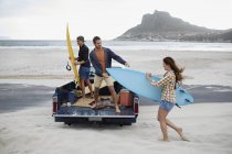 Friends with surfboards on beach. — Stock Photo