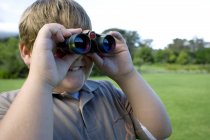 Obeso ragazzo utilizzando binocolo all'aperto
. — Foto stock