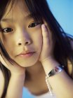 Elementary age Asian girl wearing medical identification tag. — Stock Photo