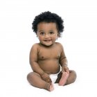 Baby girl sitting and smiling on white background. — Stock Photo