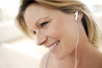 Mujer escuchando música a través de auriculares . - foto de stock
