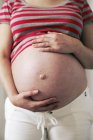 Vista ritagliata dell'addome della donna incinta . — Foto stock