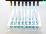 Multipipette und Fläschchen für genetische Forschung auf weißem Hintergrund. — Stockfoto