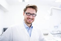 Portrait of mid adult male dentist in glasses. — Stock Photo