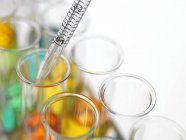 Close-up of pipetting colorful liquids into test tubes. — Stock Photo