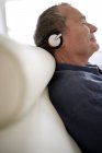Hombre con auriculares y relajarse en casa - foto de stock