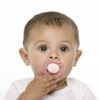 Portrait de bébé fille avec sucette rose . — Photo de stock