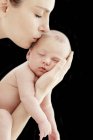 Mãe beijando o bebê recém-nascido dormindo filho, estúdio tiro . — Fotografia de Stock