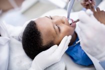 Закри стоматолог свердління зубів хлопчика в клініці. — стокове фото