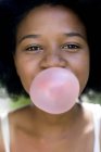 Retrato de la muchacha que sopla burbuja rosada . - foto de stock