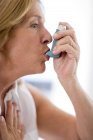 Retrato de mulher idosa usando inalador de asma . — Fotografia de Stock