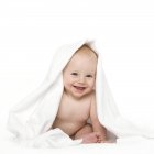 Bambino ragazzo sorridente sotto coperta . — Foto stock
