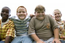 Portrait of group of elementary age boys sitting outdoors. — Stock Photo