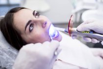 Paciente recebendo procedimento ultravioleta na clínica odontológica . — Fotografia de Stock