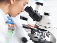 Female scientist viewing tissue sample under microscope. — Stock Photo