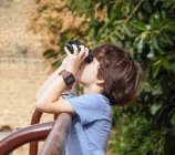 Giovane birdwatcher maschio che guarda attraverso il binocolo — Foto stock