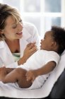 Female doctor playing with baby patient at examination in clinic. — Stock Photo