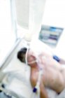 Primer plano del goteo intravenoso del paciente en la sala de cuidados intensivos . - foto de stock