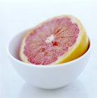 Close-up view of pink grapefruit half in bowl. — Stock Photo