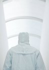 Visão traseira do cientista masculino em terno de isolamento branco no corredor . — Fotografia de Stock