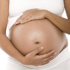 Vista ritagliata della donna incinta che tiene l'addome . — Foto stock