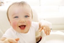 Portrait of happy baby boy in high chair. — Stock Photo