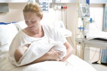 Donna in reparto maternità con neonato in braccio . — Foto stock